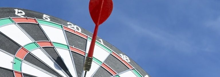 Close up shot red darts arrows in the target ,arrow hitting the center of a shooting target for business close targeting and good success.Business target or goal success and winner concept.